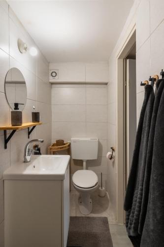 a bathroom with a toilet and a sink and a mirror at Dotan's Boutique Studios - By Gordon Beach! in Tel Aviv