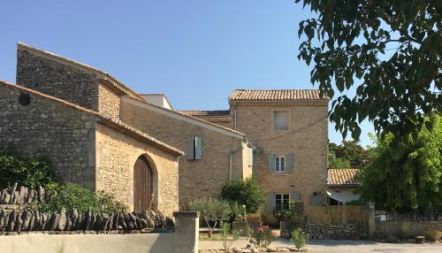 - un grand bâtiment en pierre avec une porte devant dans l'établissement Mascalou, à Cabrières-dʼAvignon