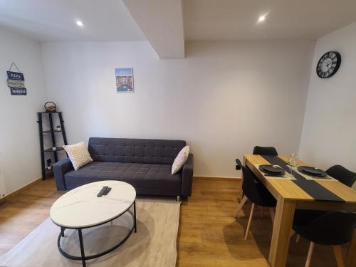 un salon avec un canapé et une table dans l'établissement Le Rivage Ébène & Distinction, à Dieppe