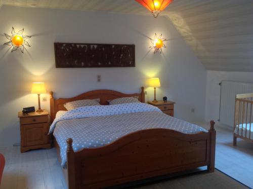 a bedroom with a bed with two lights on the wall at Vakantiewoning Ijzerrust in Roesbrugge-Haringe