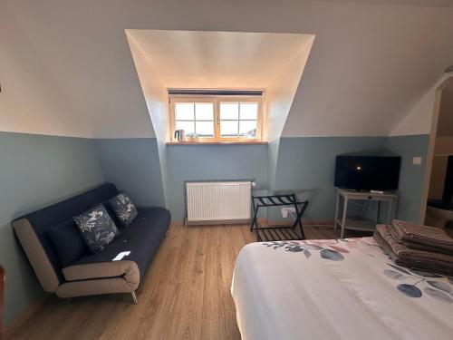 a room with a bed and a couch and a window at Les Cigognes de Rosheim in Rosheim