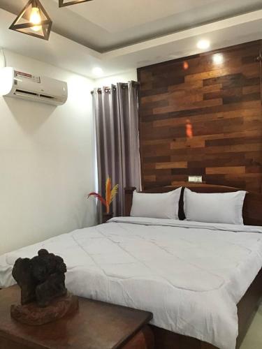 a bedroom with a large bed with a wooden headboard at Liza Boutique in Phumi Ta Phul