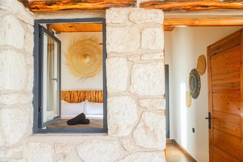 a mirror on a stone wall in a bedroom at Smaylo Surf House in Sidi Kouaki