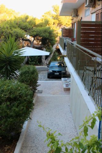 a car parked next to a balcony with an umbrella at Hermes in Agia Marina Aegina
