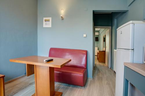 a red leather chair sitting next to a wooden table at Heliotrope The Studios in Mytilini
