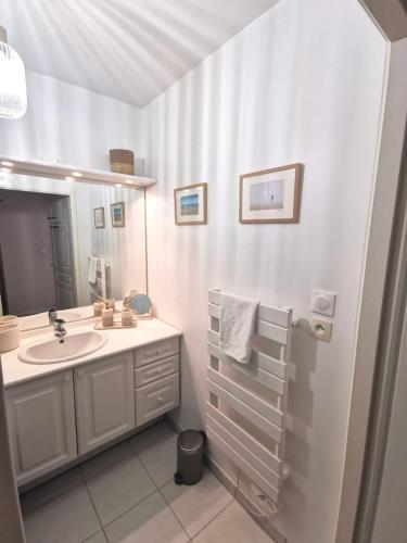 une salle de bain blanche avec un lavabo et un miroir dans l'établissement Nouveau - Sérénité, à Nantes