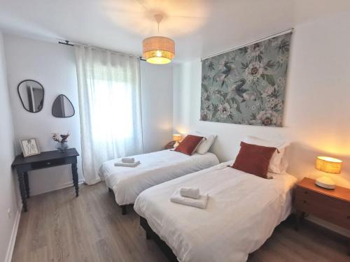 une chambre avec deux lits et un tableau au mur dans l'établissement Nouveau - Sérénité, à Nantes