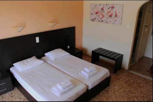 a bedroom with a large bed with white sheets at Hermes in Agia Marina Aegina