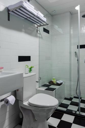 Un baño con inodoro, lavabo y ducha. en The New Port Hotel TLV, en Tel Aviv
