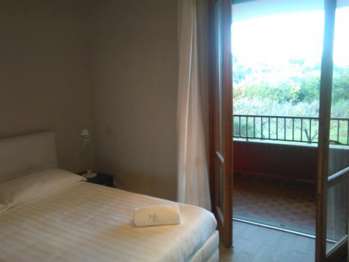a bedroom with a bed and a balcony with a window at Hotel Eremo in Soriano nel Cimino