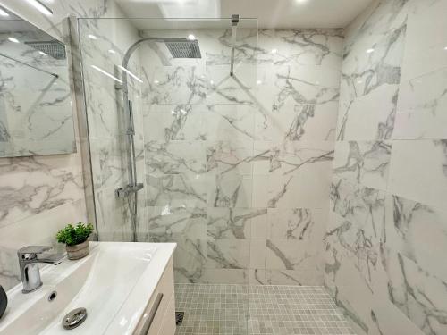 une salle de bain blanche avec une douche et un lavabo dans l'établissement Studio cosy au cœur de Cannes, à Cannes