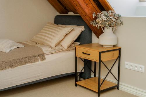a bed with a vase of flowers on a night stand at Massu kiviait in Massu