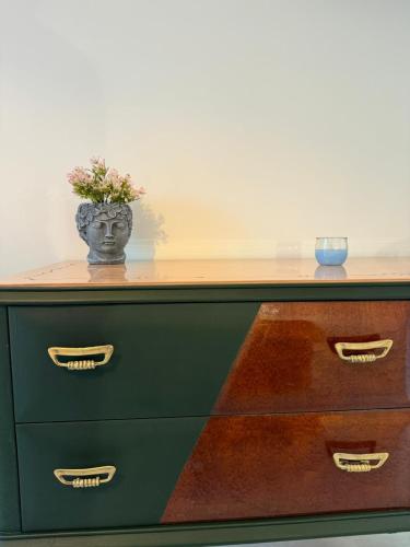 a dresser with a vase on top of it at Avi Rooms in Chiaramonte Gulfi