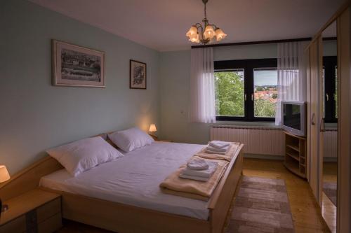 a bedroom with a bed with towels on it at Apartment VI&MI in Slunj