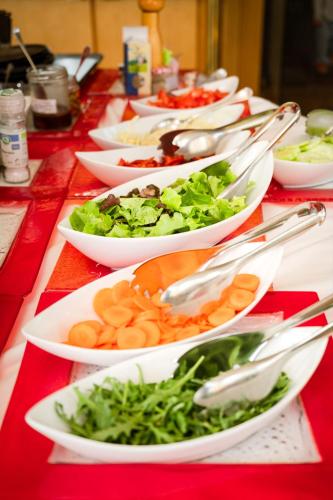 a long red table with plates of food on it at Panoramahotel Wagner - Das Biohotel am Semmering in Semmering