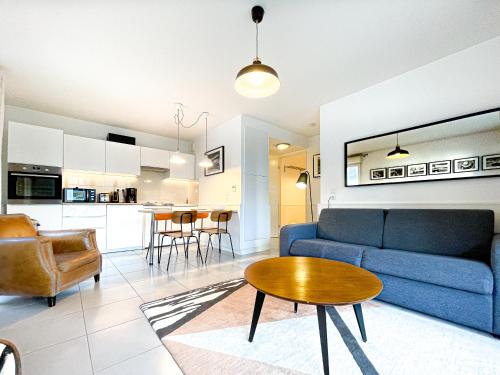 un salon avec un canapé bleu et une table dans l'établissement Appartements avec Terrasse - Cite du Vin, à Bordeaux