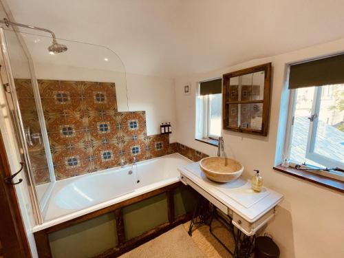 une salle de bains avec baignoire et lavabo dans l'établissement Charming Cottage Sleeps 4 with Sauna, à Shaftesbury