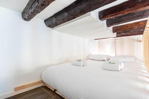 une chambre avec un lit blanc avec deux oreillers dans l'établissement GuestReady - Apt Élégant Proche du Panthéon pour 3, à Paris