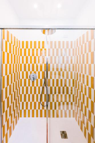 a shower with a yellow and white checkered wall at Casa Don Matteo in Scala