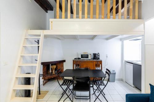 Cette chambre comprend une table et une mezzanine. dans l'établissement GuestReady - Apt Élégant Proche du Panthéon pour 3, à Paris