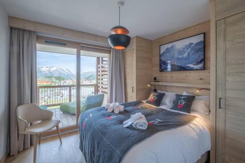 - une chambre avec un lit et des serviettes dans l'établissement Alpe d'Huez Houses - Alpe Forever - PHOENIX3 - 3 chambres 5 étoiles pour 6 à 8 skis aux pieds, à L'Alpe-d'Huez