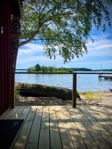 a wooden porch with a view of a lake at Bergs Gård & Hållsvikens Gård in Västerljung