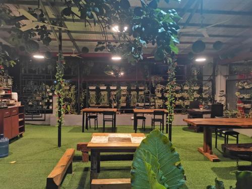 a room filled with wooden tables and plants at Jkenter Suites in Koronadal