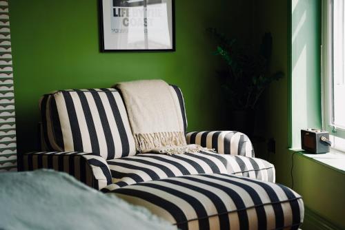 a green room with a chair and a blanket at The London & Paris Hotel in Folkestone