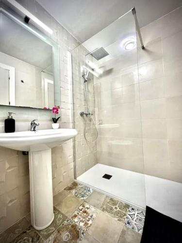a white bathroom with a sink and a shower at KS Maral Home - Kaleria Suites in Aguadulce