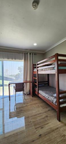 a bedroom with two bunk beds and a desk at Chinyonga Guesthouse in Limbe