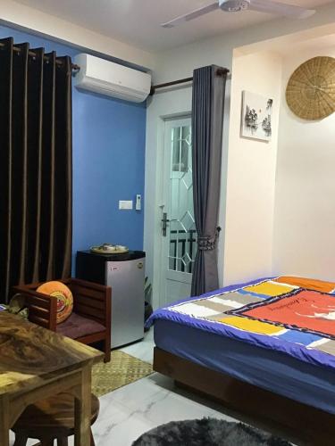 Phumĭ Ta PhŭlにあるKitya Homestayのベッドルーム1室(ベッド1台、テーブル、ドア付)