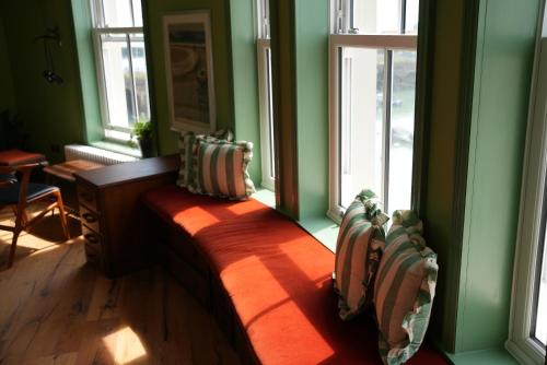 a room with a bench in a room with windows at The London & Paris Hotel in Folkestone