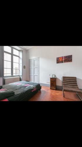 une chambre avec un lit et une chaise dedans dans l'établissement Beziers centre historique, à Béziers