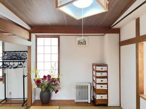 a room with a vase of flowers and a skylight at 板東ビル in Tokyo