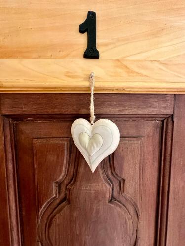 a heart hanging on a door with a number at Maison Rosset agriturismo, camere, APPARTAMENTI e spa in Valle d'Aosta in Nus