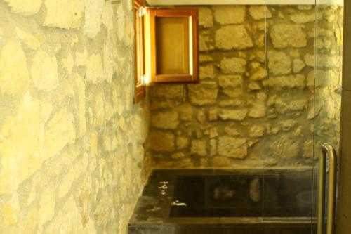 a bathroom with a stone wall and a window at Il Carosello dei Baroni in Noto