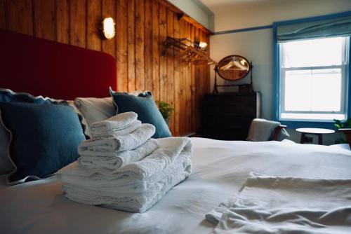 a pile of towels sitting on top of a bed at The London & Paris Hotel in Folkestone