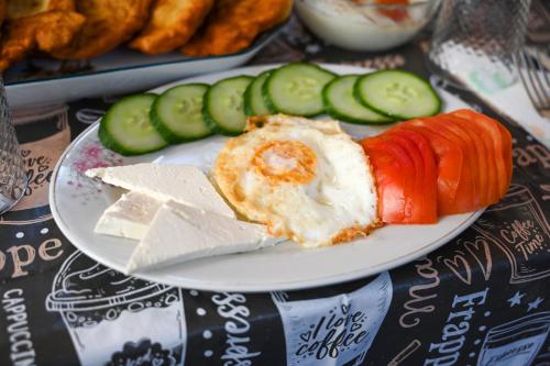 a plate of food with vegetables on a table at Guest House Flowers in Berat