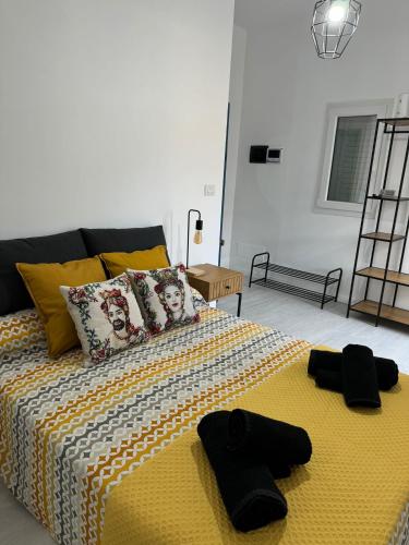 a bedroom with a bed with two black gloves on it at Avi Rooms in Chiaramonte Gulfi