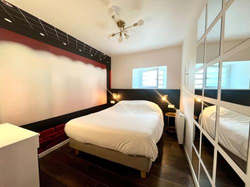 a bedroom with two beds and a ceiling fan at Le Moovie - Centre-ville- Écran cinéma in Sens