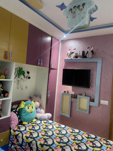 ein Kinderschlafzimmer mit einem Bett und einem TV in der Unterkunft Said alami in Temara