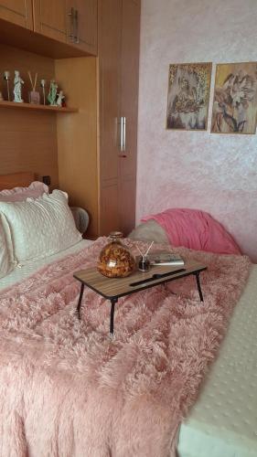 ein rosa Bett mit einem Tisch darauf in der Unterkunft Said alami in Temara