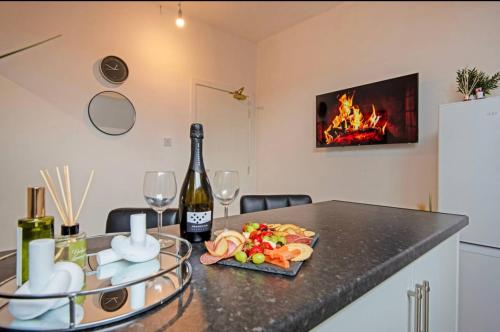 a table with a bottle of wine and a plate of food at 5 minute walk from Bury city centre -1 bed flat in Bury