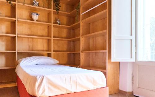 a bedroom with a bed with wooden shelves at Leonardo Da Vinci's House in Pisa