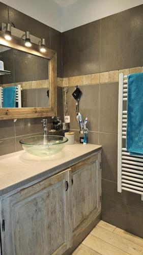 La salle de bains est pourvue d'un lavabo et d'une serviette bleue. dans l'établissement appartement terrasse vue mer, à Sète