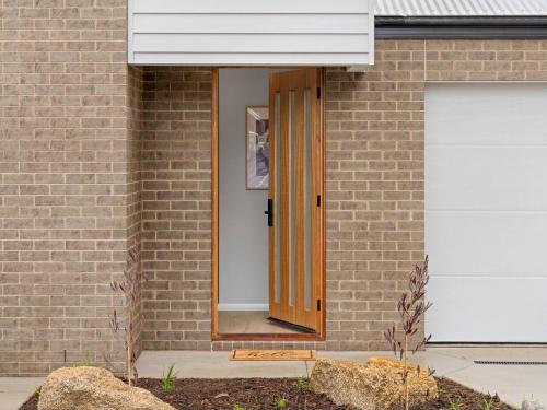 an open door on a brick building with a garage at Central Studio in new townhouse in Beechworth