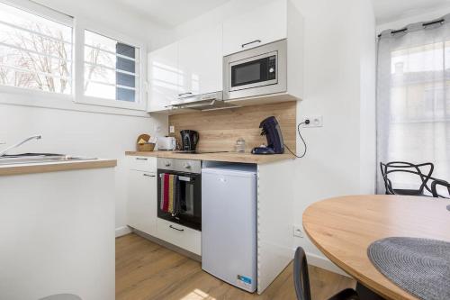 - une cuisine avec une table et un four micro-ondes dans l'établissement Portet - Appartement 4, à Portet-sur-Garonne