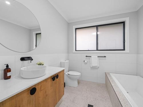 Un baño con lavabo, inodoro y bañera. en Brand new 3 bed townhouse walk to town, en Beechworth