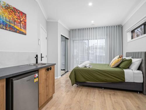 1 dormitorio con cama y lavamanos en Brand new 3 bed townhouse walk to town, en Beechworth