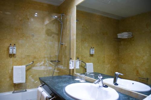 a bathroom with a sink and a shower at Sercotel Palacio de Tudemir in Orihuela